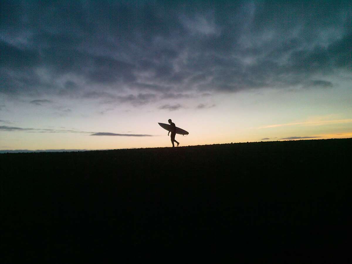 Surfer at sunset on  Newgale Beach Pembrokeshire