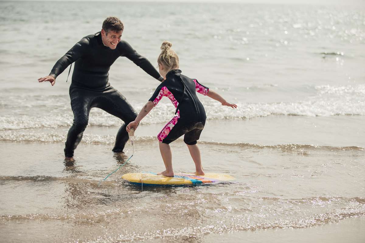 Father and daughter learning to surf