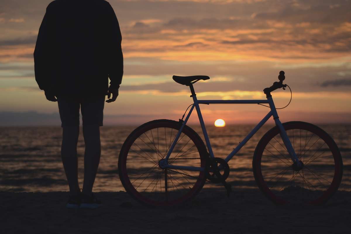 Cyclist by pembrokeshire beach at sunset