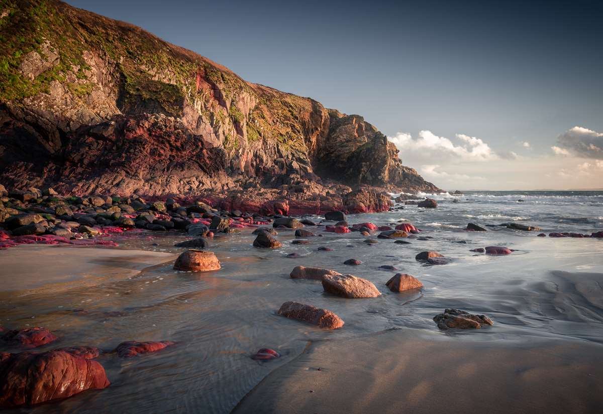 The brightly coloured rocks at Caerfai at sunset