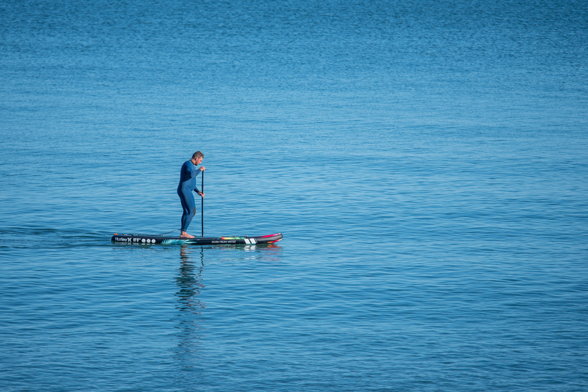 Man paddleboarding at Coppet Hall in Saundersfoot